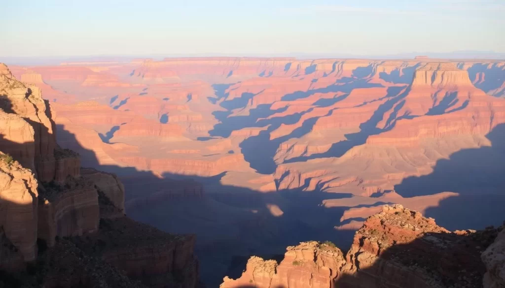 A sweeping vista of the majestic Grand Canyon, its vast expanse of layered rock formations and deep, winding gorges bathed in warm, golden sunlight. In the foreground, rugged cliffs and towering rock spires rise majestically, casting dramatic shadows across the scene. The middle ground reveals the canyon's breathtaking depth, with its intricate patterns of striated rock in shades of red, orange, and tan. In the distant background, the horizon is punctuated by the dramatic silhouettes of distant buttes and mesas, creating a sense of scale and grandeur. The overall atmosphere is one of awe-inspiring natural beauty, inviting the viewer to discover the sheer magnificence of this natural wonder.