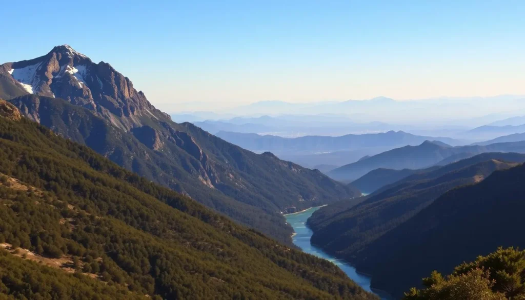 A majestic landscape of the San Gabriel Mountains emerges, bathed in warm, golden sunlight. Towering peaks rise from a lush, forested foreground, their rugged slopes dotted with patches of snow. In the middle ground, a winding river cuts through the valley, its crystalline waters reflecting the azure sky above. The background is dominated by a panoramic vista of distant mountain ranges, their silhouettes fading into the hazy horizon. The overall scene conveys a sense of tranquility and grandeur, inviting the viewer to explore the natural wonders of this iconic California landscape.