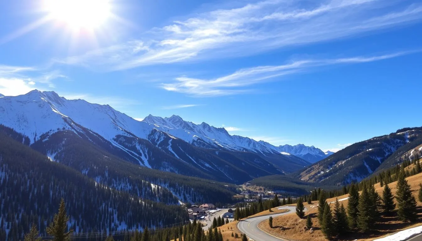 A majestic mountain landscape with the iconic Crested Butte ski resort nestled in the valley below. The sun casts a warm, golden glow over the snow-capped peaks, their rugged slopes dotted with evergreen trees. In the foreground, a winding alpine road leads the eye towards the resort, its charming buildings and ski runs visible in the middle ground. The sky is a brilliant blue, with a few wispy clouds drifting overhead. The overall scene conveys a sense of tranquility and natural beauty, inviting the viewer to imagine themselves immersed in the serene mountain setting.