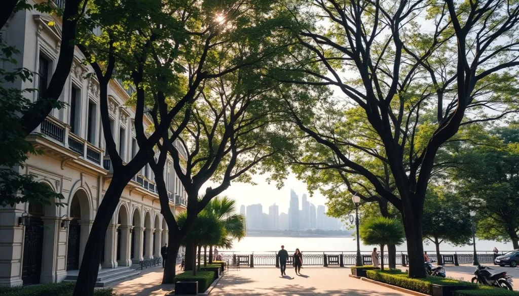 A tranquil streetscape on Shamian Island, Guangzhou, China. In the foreground, colonial-era buildings with elegant European architectural features line a picturesque promenade. Trees and lush greenery frame the scene, casting dappled shadows. In the middle ground, pedestrians stroll leisurely, capturing the island's relaxed, historical ambiance. The background features the Pearl River glistening under a warm, sunlit sky, with distant skyscrapers of modern Guangzhou visible on the horizon. The overall scene conveys a harmonious blend of Guangzhou's colonial heritage and natural beauty.