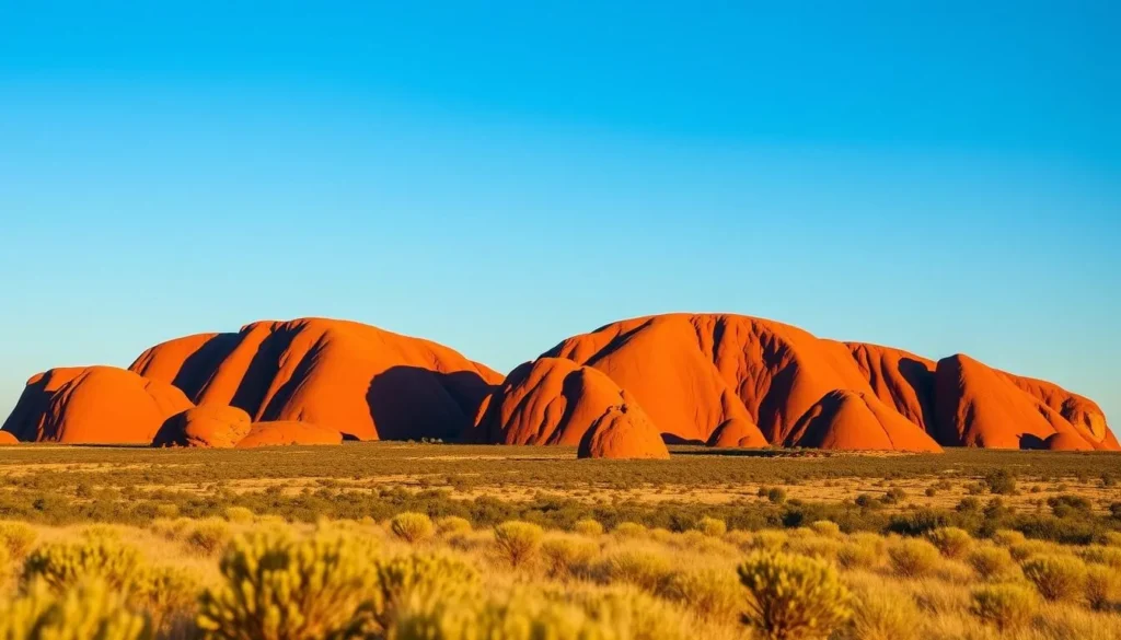 The domes of Kata Tjuta glowing orange in the morning light with a clear blue sky, Best Things to Do in Yulara, Northern Territory The domes of Kata Tjuta glowing orange in the morning light with a clear blue sky, Best Things to Do in Yulara, Northern Territory