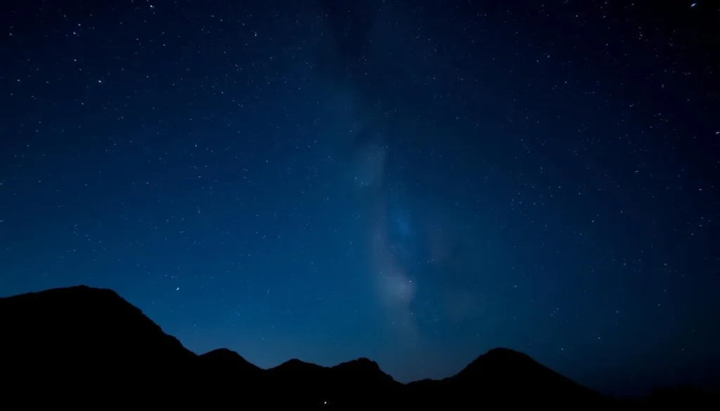 Night sky over Sambawan Island showing stars and the Milky Way with silhouettes of the island's hills