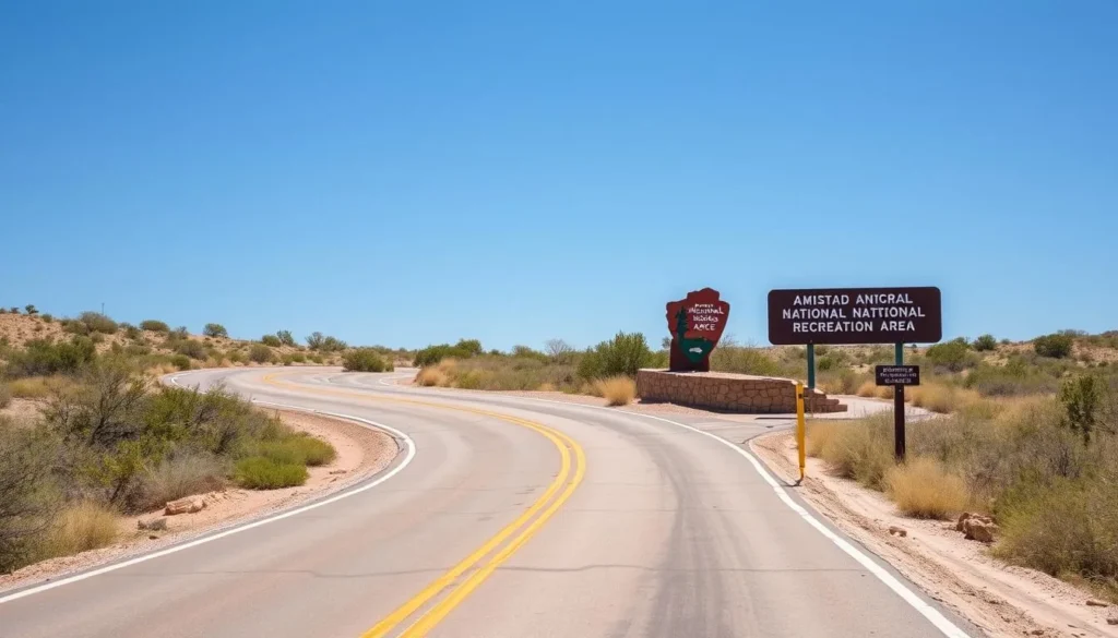 Road leading to Amistad National Recreation Area entrance sign with desert landscape in the background