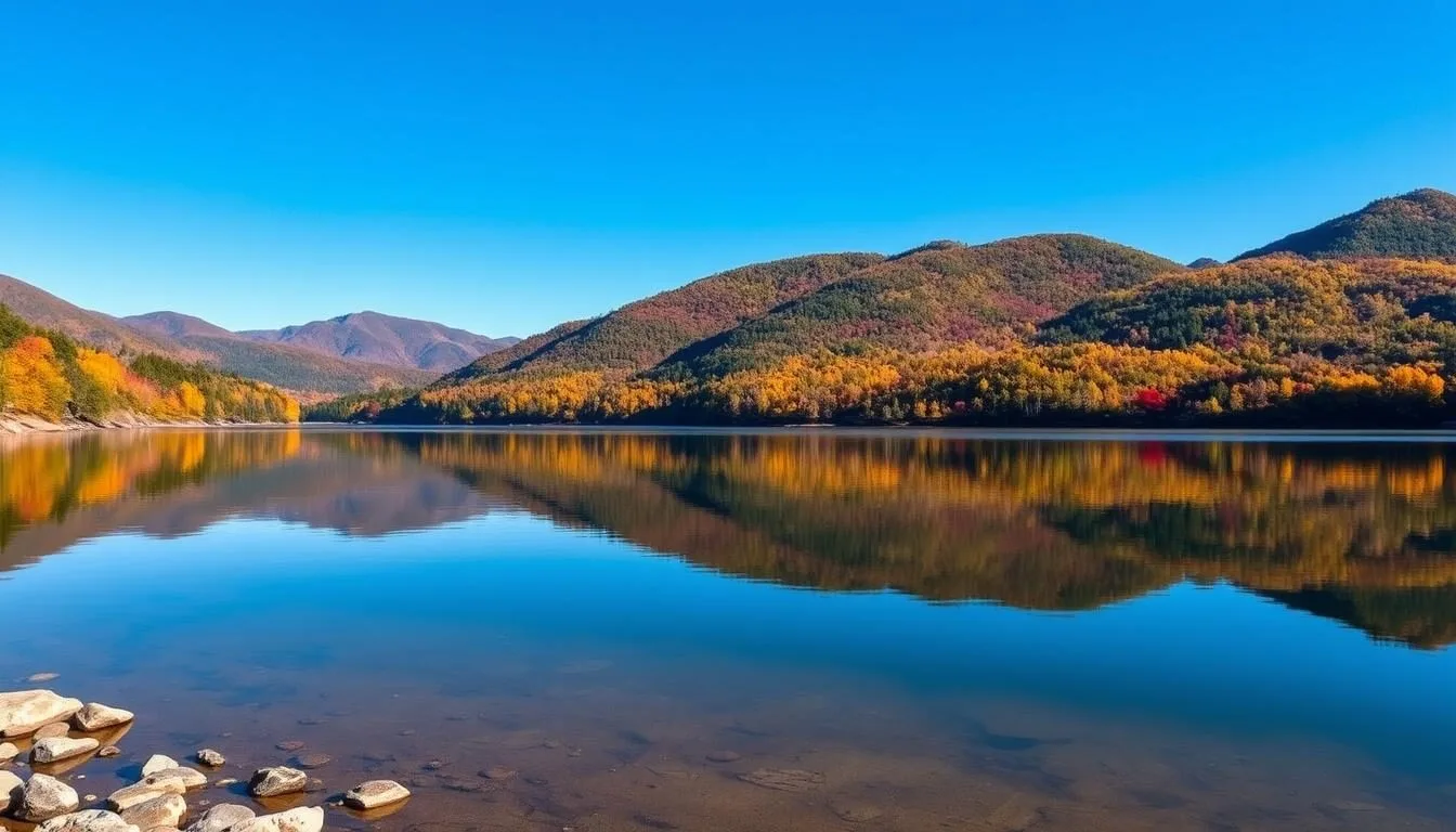 Scenic-view-of-Lake-Lacawac-with-surrounding-autumn-foliage-and-mountains-in-the-background Scenic view of Lake Lacawac with surrounding autumn foliage and mountains in the background