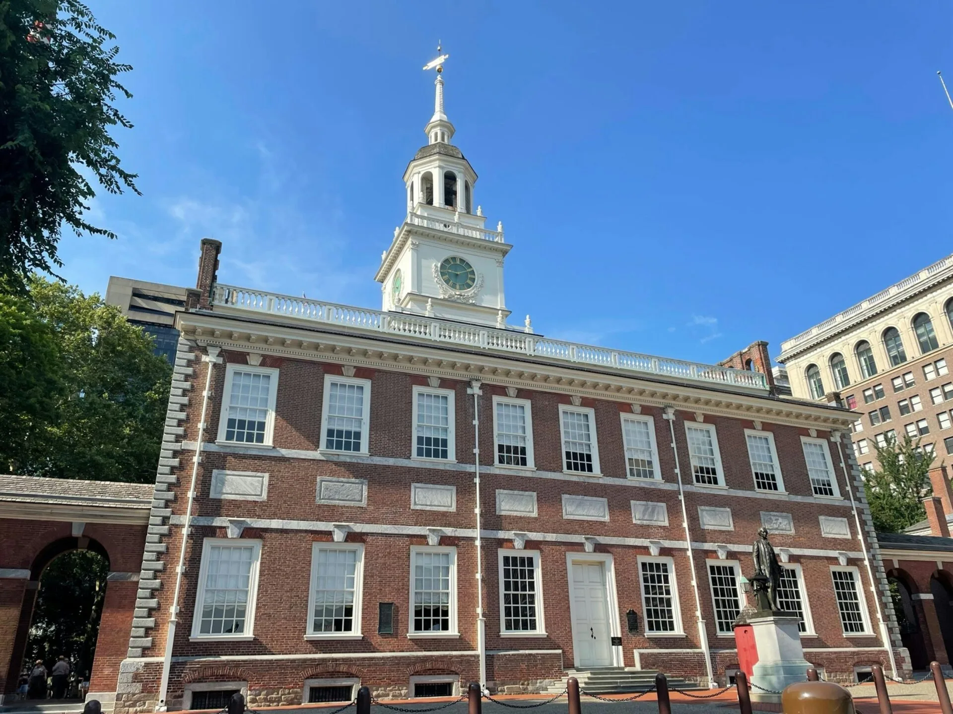 a-large-brick-building-with-a-clock-tower-with-Independence-Hall-in-the-background a large brick building with a clock tower with Independence Hall in the background