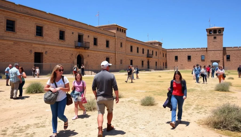 Visitors exploring the prison yard at Yuma Territorial Prison during comfortable weather with sunshine