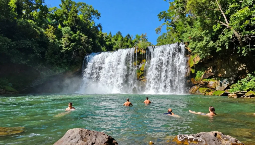 Elk River Falls during summer with visitors swimming in the clear pool beneath the waterfall Elk River Falls during summer with visitors swimming in the clear pool beneath the waterfall
