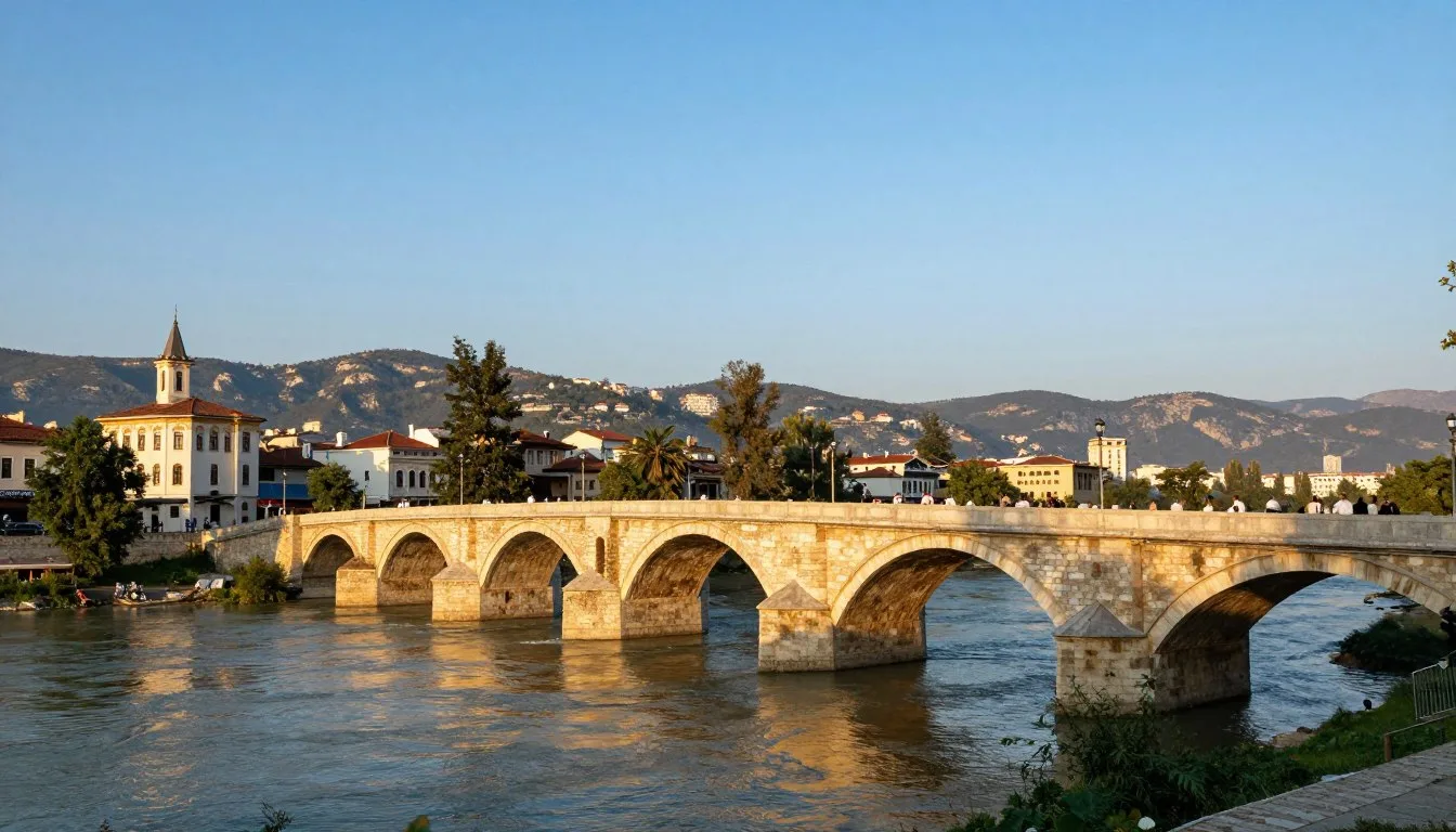 Historic Stone Bridge spanning Vardar River in Skopje with Mount Vodno in background