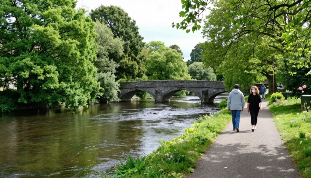 River Nore walking path with lush greenery and medieval stone bridge